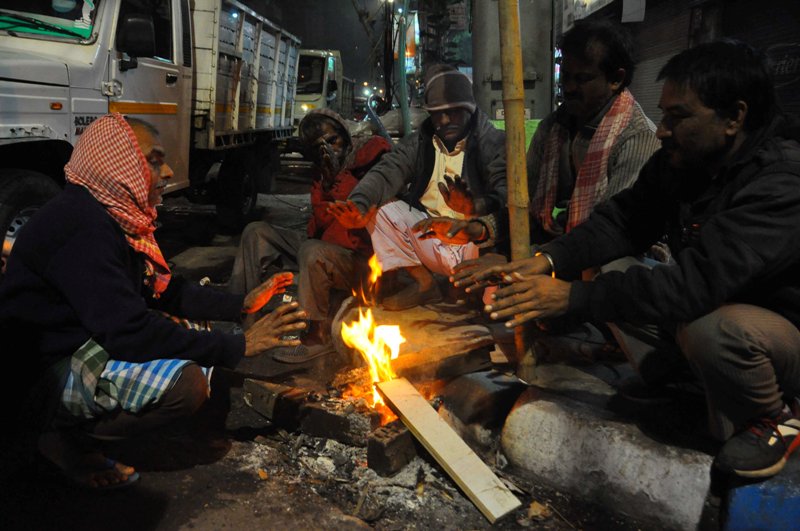 People warm up before fire to fight cold in Kolkata 