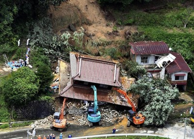 Japan: Excavators removing house damaged by a mudslide