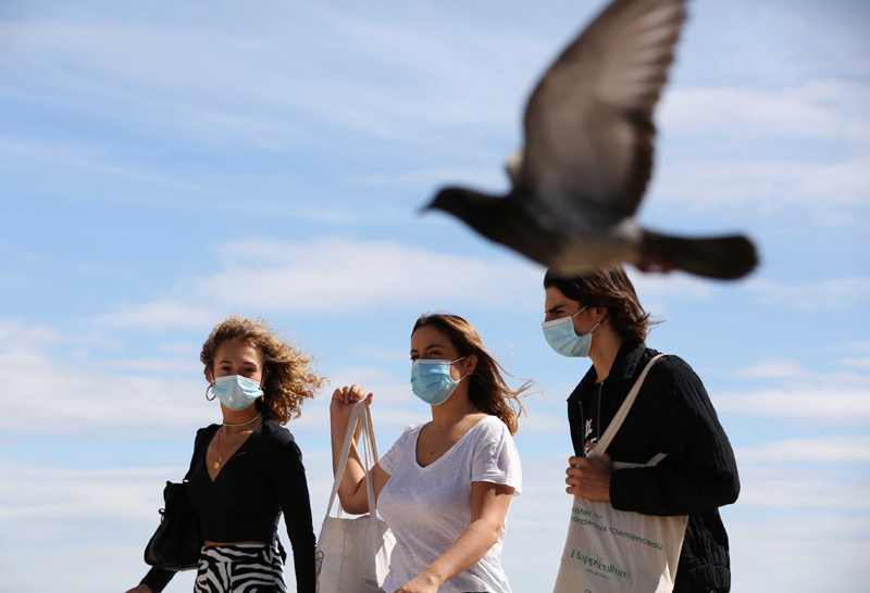 A glimpse of people wearing masks on Trocadero Place near Eiffel Tower in Paris
