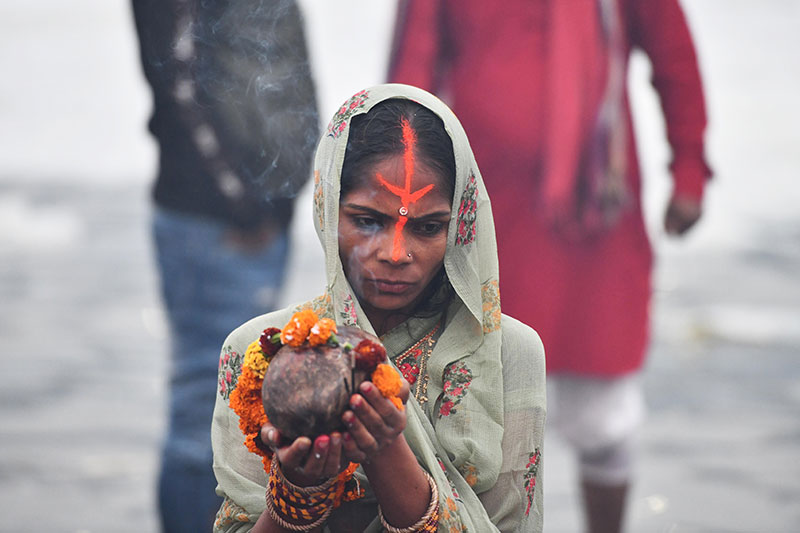 Devotees worship the rising sun at the banks of Yamuna in Delhi