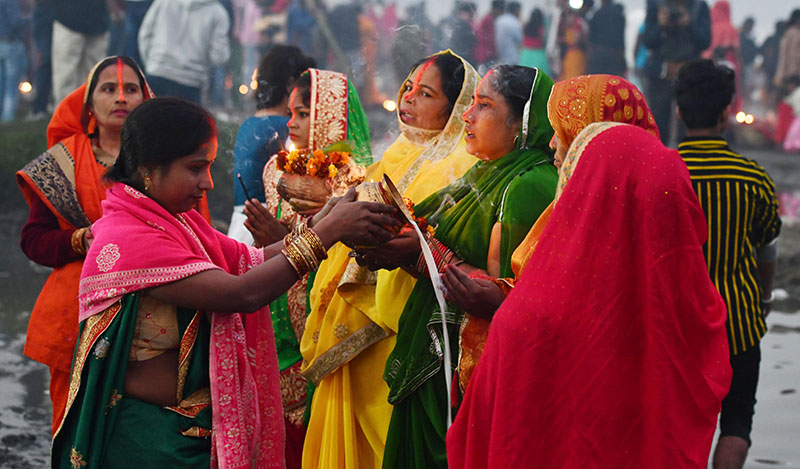 Devotees worship the rising sun at the banks of Yamuna in Delhi
