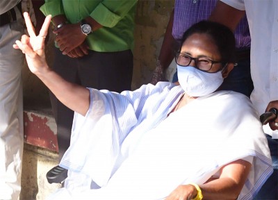 Mamata Banerjee sports a victory sign after casting her vote today
