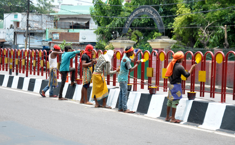 Labourer painting divider on a road as Lucknow preps up for Prez's arrival